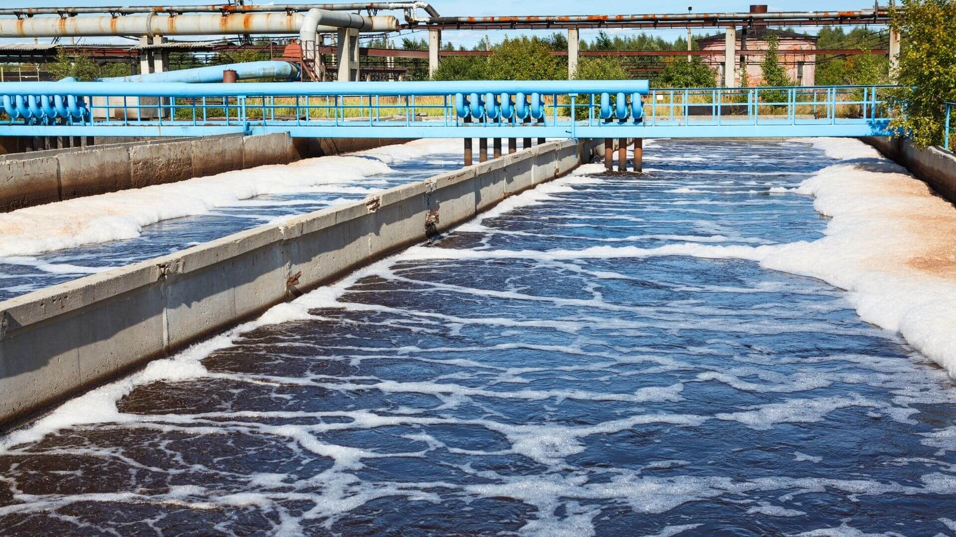 Aeration basin at California wastewater treatment plant with foam control system and industrial piping
