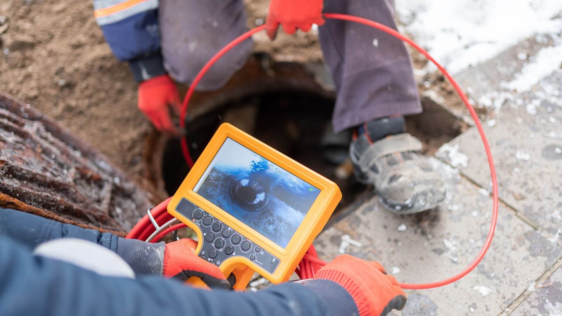 Technician performing sewer line inspection with video camera equipment in California municipal wastewater system
